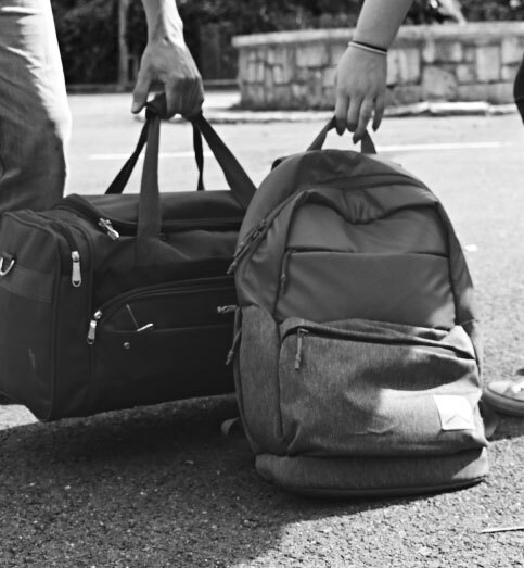 black and white photo of traveling bags being carried outside