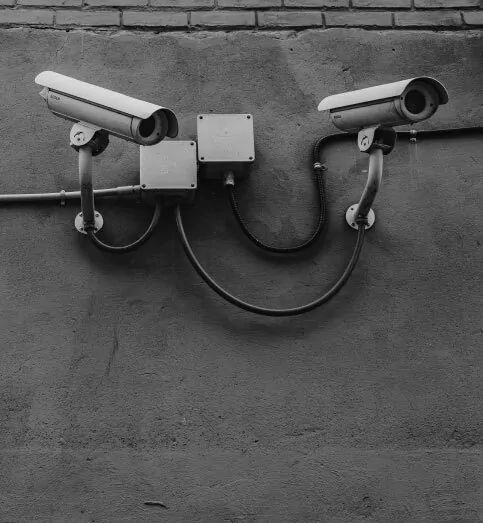 black and white photo of security cameras on a wall
